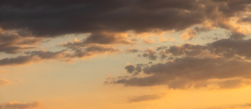 Panoramic evening sky with scattered clouds during warm sunset