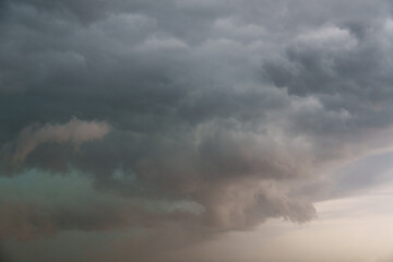 Obraz premium Dark storm clouds heavy sky background, dramatic thunderstorm cumulus cloudscape before rain, moody weather forecast backdrop, threatening hurricane or cyclone danger conceptual nature wallpaper.