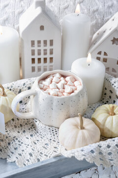 autumn background. Cozy Autumn Hot Chocolate with Mini Pumpkins and Fall Decor Warm mug of hot chocolate with mini marshmallows, white pumpkins and home decor. Inviting autumn scene