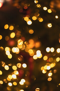 Warm golden bokeh lights glowing on dark background for Christmas and holiday celebration