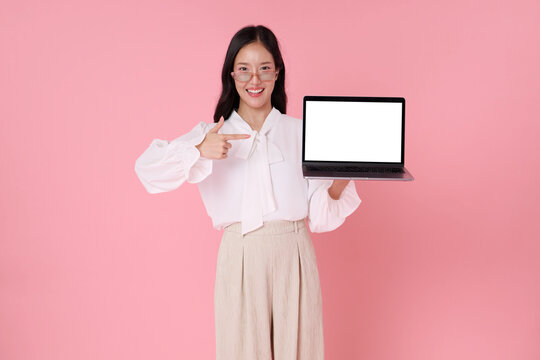 Businesswoman holding laptop with blank screen and pointing presenting digital marketing mockup for online business technology promotion advertising presentation and modern productivity.