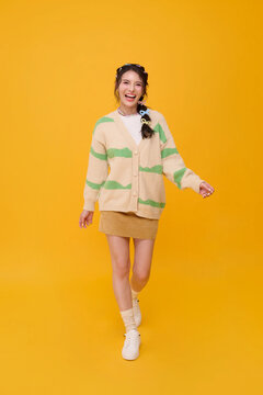 young woman walking and smiling in studio expressing happiness confidence positive energy carefree lifestyle optimism self expression youthful freedom and everyday wellbeing.