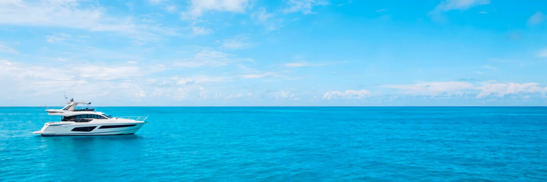 Luxury motor yacht anchored in turquoise tropical ocean water with copy space
