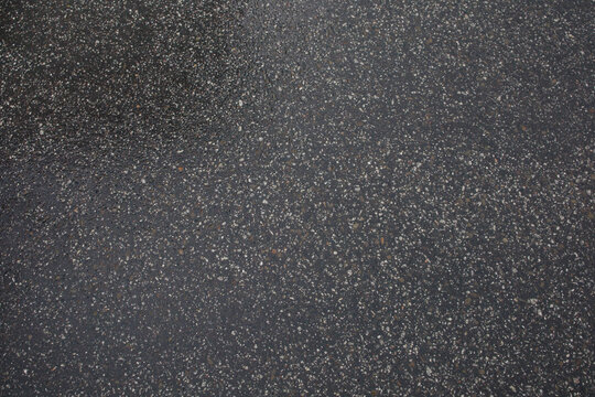 Wet asphalt after the rain close up. Minimalistic background, texture of the road after raining, weather changes.