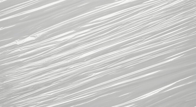 Abstract high-resolution texture of stretched transparent plastic wrap creating diagonal wrinkles and light reflective patterns ideal for modern graphic background overlay designs