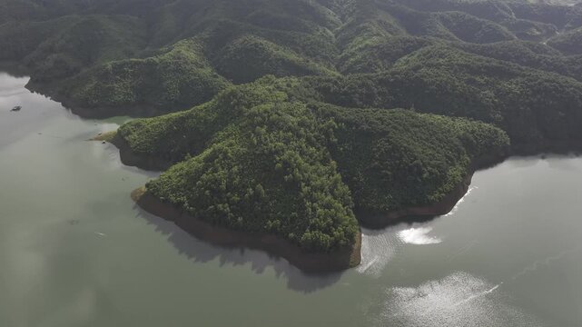 Aerial drone view of Ta Dung Lake surrounded by hundreds of green island hills and mountains in Ta Dung Commune, Lam Dong Province, Vietnam. View from QL 28. D Log mode