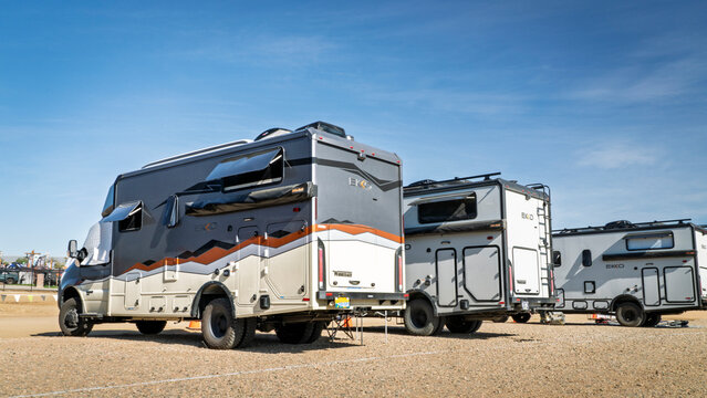 Loveland, CO, USA - August 21, 2026: Three Winnebago EKKO camper vans, Class C coach, built on Ford AWD Transit Chassis at a busy campground.