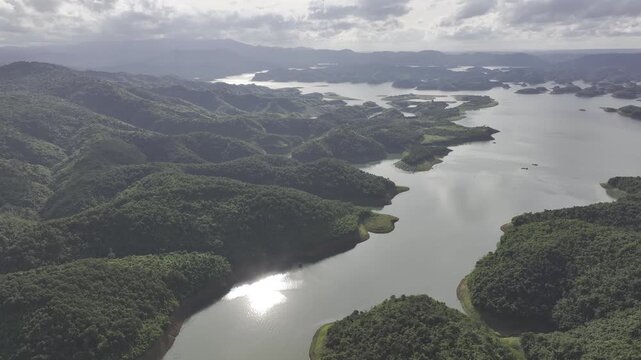 Aerial drone view of Ta Dung Lake surrounded by hundreds of green island hills and mountains in Ta Dung Commune, Lam Dong Province, Vietnam. View from QL 28. D Log mode