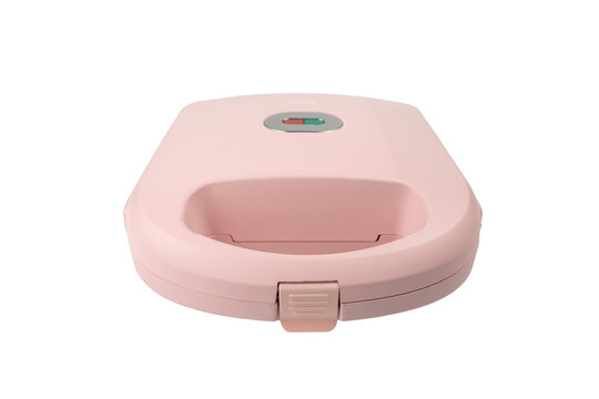 A closed pink sandwich toastie maker is shown from a low front angle, highlighting its rounded body and front latch clasp on white.
