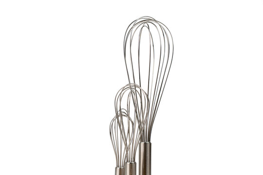 Three stainless steel whisks of different sizes stand bundled together, cropped closely to show only their wire heads on white.