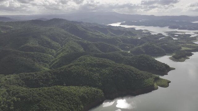 Aerial drone view of Ta Dung Lake surrounded by hundreds of green island hills and mountains in Ta Dung Commune, Lam Dong Province, Vietnam. View from QL 28. D Log mode