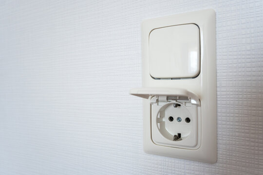 Outlet socket in the white wall for apartment interior. Electricity at home.