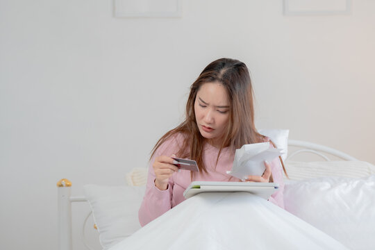 Financial stress concept. Young woman reviewing household bills and expenses at home while planning personal budget and managing monthly finances. Finance, budget, bills, expenses, planning