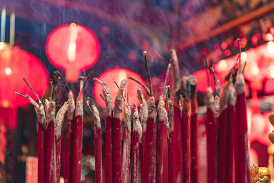 Closeup of burning incense sticks producing fragrant smoke inside a Chinese temple