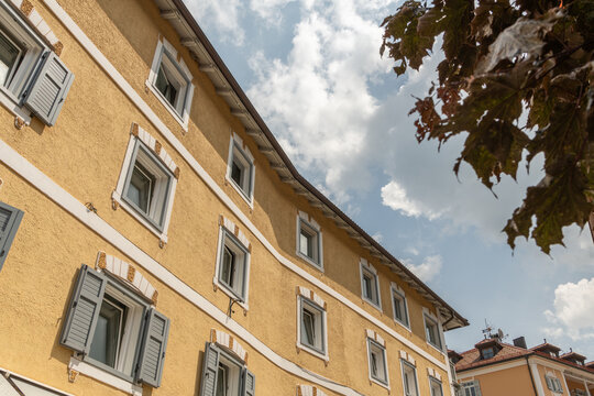 Ortisei, Urtij&euml;i, St. Ulrich, Italy. Traditional Alpine building with yellow stucco facade, decorative window frames and shutters in Val Gardena