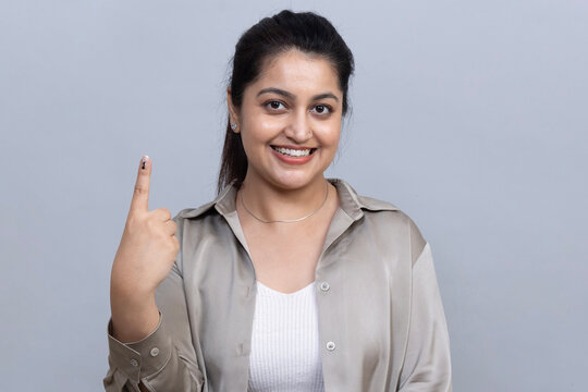 Confident young Indian woman raising her index finger in a studio portrait to symbolize My Vote My Right, voter empowerment, democratic freedom, civic participation and awareness of voting rights.