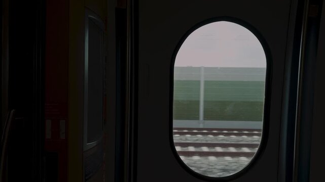 Cinematic horizontal view framed by the distinctive oval window of a moving high-speed train, transforming the passing German landscape into a natural visual frame.