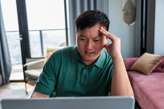 Stressed man working remotely on his laptop at home.