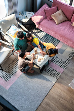 A family bonds while playing with wooden building blocks.