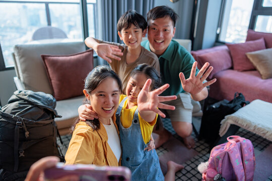 A happy family waving for a vacation selfie.