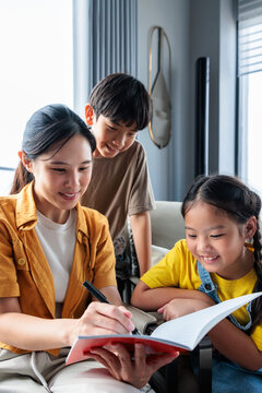 Mother and children studying together at home.