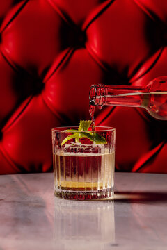 Pouring a crystal clear cocktail into a glass 