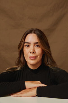 Confident young woman smiling with freckles and long hair