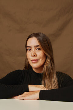 Young woman confidently posing with hands on table