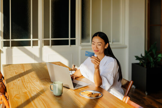 Woman doing online shopping with credit card and laptop