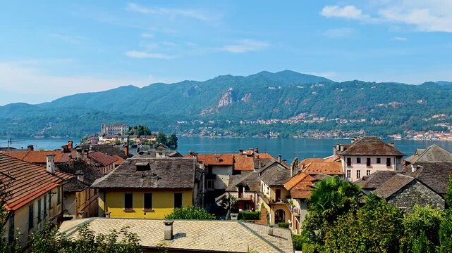 San Giulio Island on Lake Orta, Piedmont, Italy. Aerial 4K video footage with panoramic view featuring the historic basilica and picturesque lakeside scenery surrounded by Alpine landscapes