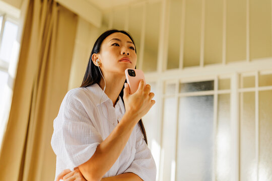 Woman listening to audio using smartphone and earbuds