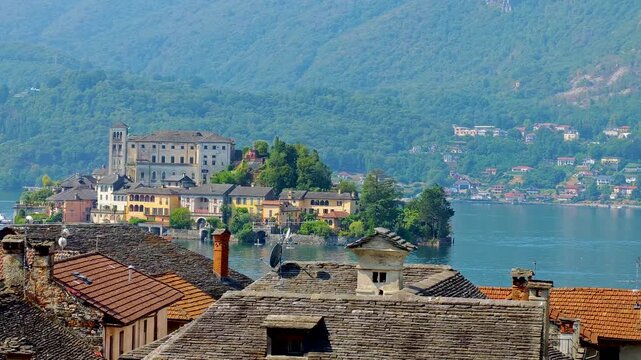 San Giulio Island on Lake Orta, Piedmont, Italy. Aerial 4K video footage with panoramic view featuring the historic basilica and picturesque lakeside scenery surrounded by Alpine landscapes