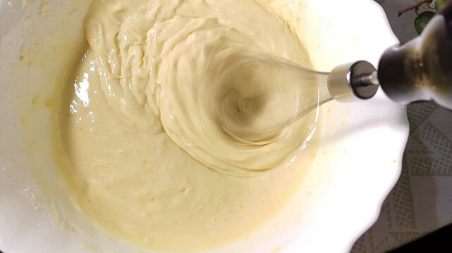 Creamy cake batter being mixed with chopped apple pieces, homemade baking preparation, fruit dessert, cooking process, apple cake.