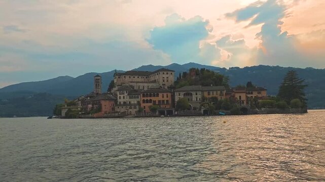 San Giulio Island on Lake Orta, Piedmont, Italy. 4K video footage from boat featuring the historic basilica and picturesque lakeside scenery surrounded by Alpine landscapes