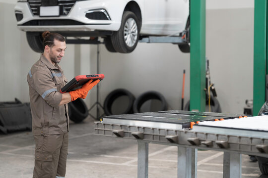 EV car repair, maintenance, inspecting services. Mechanic diagnosing battery pack, component checks, electric car vehicles battery, electric car software update, testing and install at auto workshop