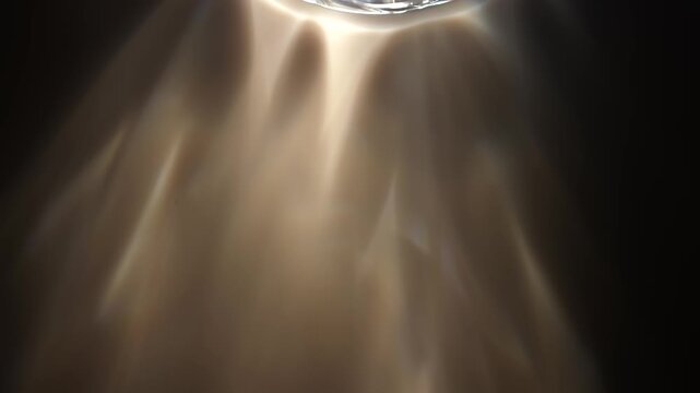 Glass rim casts soft golden reflections and caustic light patterns across a dark surface. Concept abstract optics for ads, websites, banners, magazines and presentations.