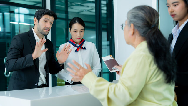 Airport personnel respond to an unhappy passenger during a tense service discussion highlighting complaint handling communication and customer relations.
