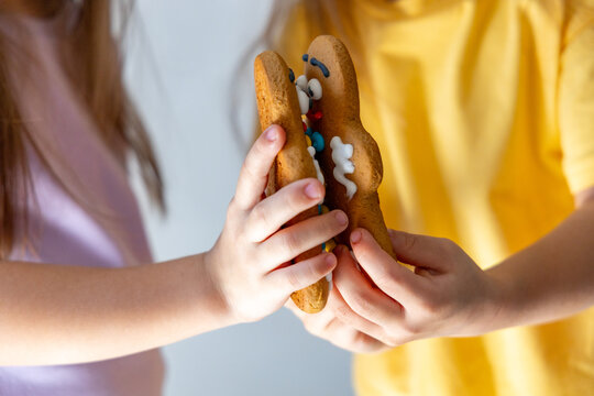 Close Up Of Children Hands Holding Decorated Gingerbread Cookie With Icing And Colorful Candies, Suggesting Festive Baking, Sweet Holiday Fun, Warm Family Tradition