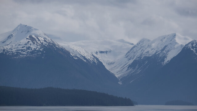 Breathtaking Alaska mountain glacier range view seen from outdoor deck of cruise ship liner sailing the Inside Passage transit with spectacular landscape wilderness scenery