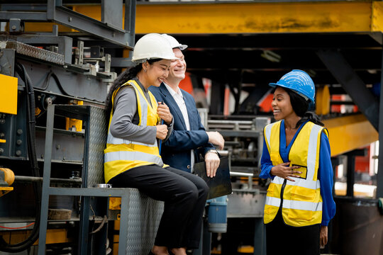 group of professional engineer, worker, technician discuss work, walk in steel metal manufacture factory plant industry. Black African American man and woman wear hard hat check quality machine