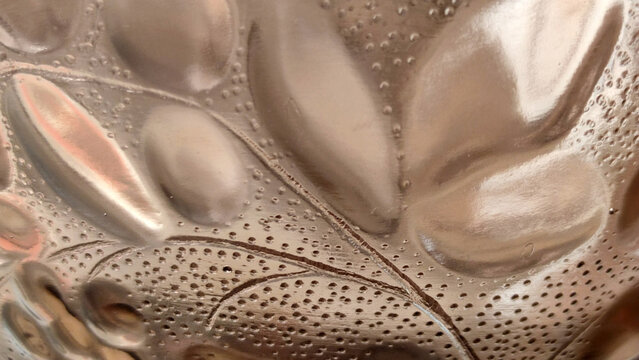 close up of leaf pattern on textured brown glass