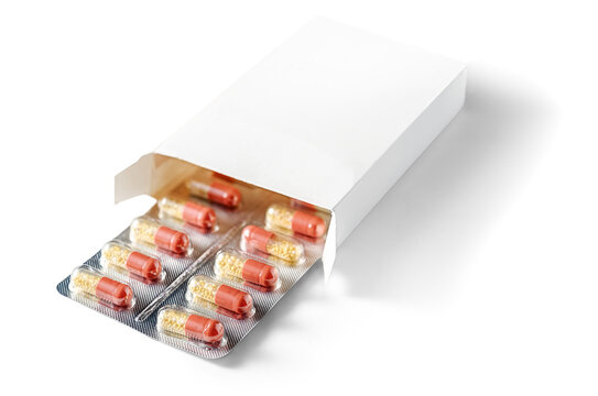 Blister pack of red and yellow capsules emerging from white medicine box on white background