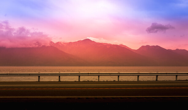 Highway sunset sky and mountains in rain: abstract geometry of roadtrip landscape in Anchorage coastal way in Alaska