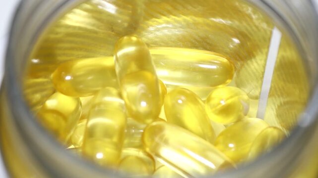 A close-up shot of fish oil in a jar, suitable for use in health and wellness-related concepts. Rotating in a circle
