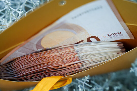 Stack of euro banknotes inside a golden gift bag representing a financial gift, cash savings and wealth