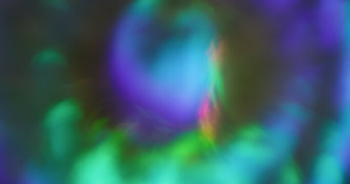 Defocused rainbow texture. Bright glow abstraction. Purple pink blue colorful round optical gleam on luminous bokeh glisten background.