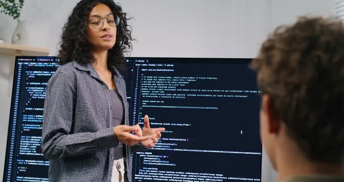 Colleagues gather in a conference room for a product workshop, presenting code flow, security measures, and deployment plan.
