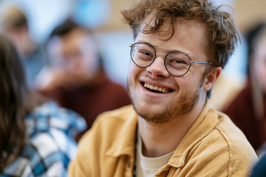 Happy Young Man with Down Syndrome Smiling in Classroom