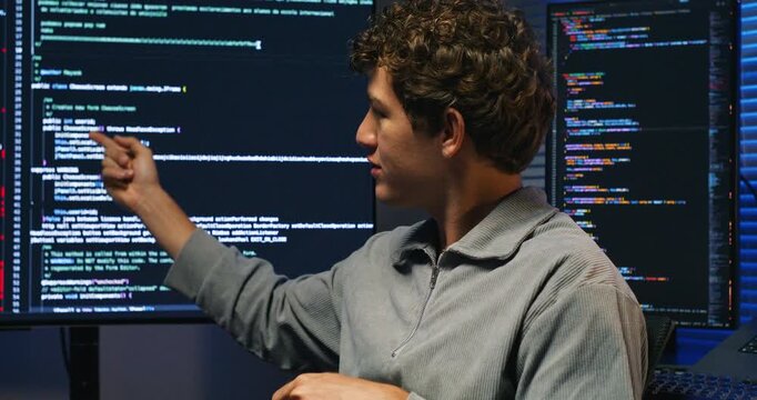 A mixed team of developers discusses architecture around a monitor, explaining system design and database strategy for the AI application.
