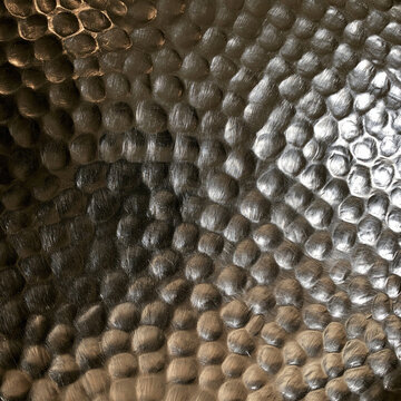 Elegent photo of Macro shot of a hammered dark metallic surface with light reflections. This industrial abstract texture is perfect for modern interior design and background.